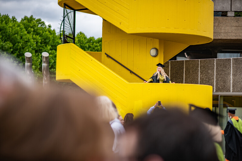 A graduating UCA student poses in an unusual location at the Southbank Centre