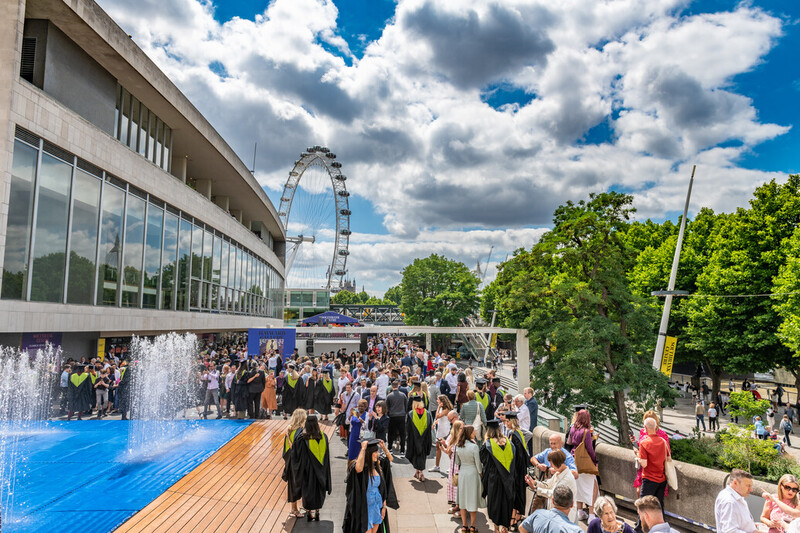 A general shot overlooking graduates, family and friends outside Royal Festival Hall, London