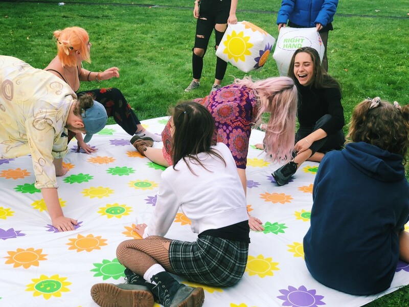 A group of new students playing a twister-style game together