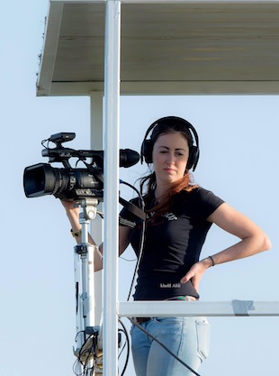 Image shows Georgina Sadler behind the camera at an F1 race