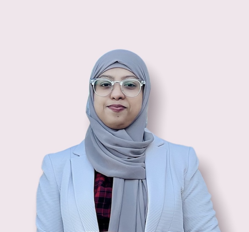A head and shoulders image of international student Umme Salma. She is wearing a pastel blue jacket and grey headscarf