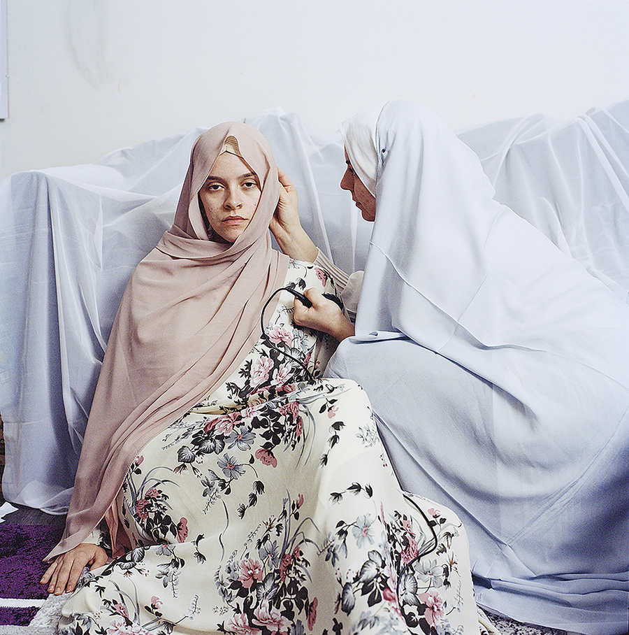 A magazine cover - Picton magazine - showing two models in pastel coloured clothing, positioned on a green leather couch