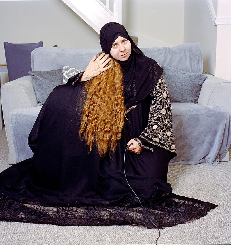 Jodie Bateman and sister Hannah wear black hijabs against a sofa