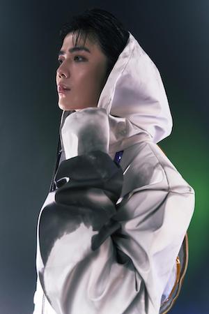 A side facing portrait of a model wearing a futuristic white hooded garment, designed by fashion student Xiaoye Gong