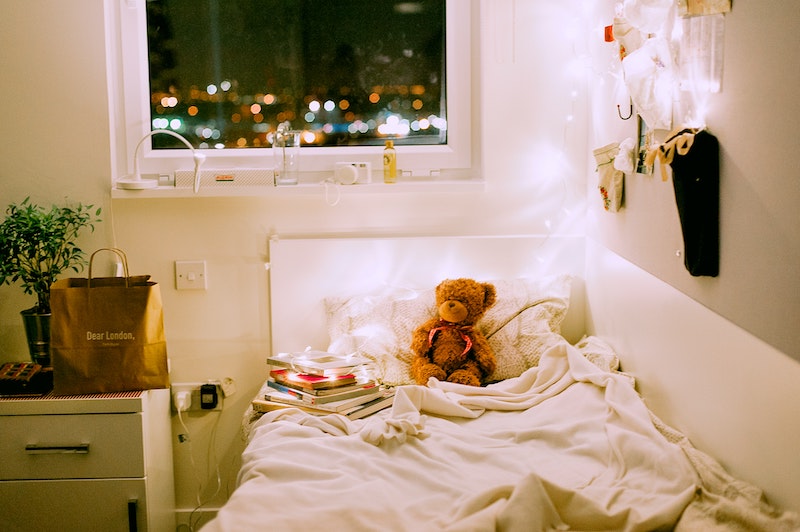 Picture shows a cosy single bedroom lit with fairy lights. Image by Daria Shevtsova via Unsplash