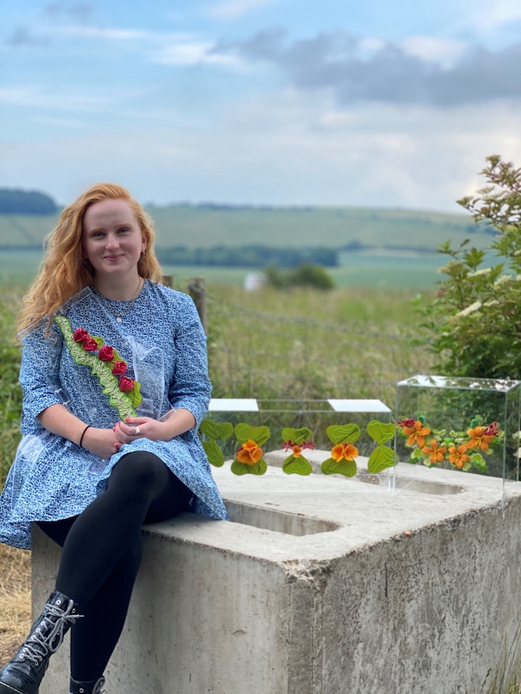 Grace Ingman sits with pieces of her work