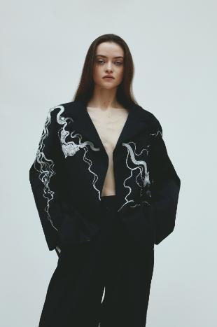 Model wears black embroidered tailoring